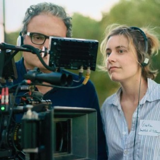 Man and a woman looking intently at a professional camera